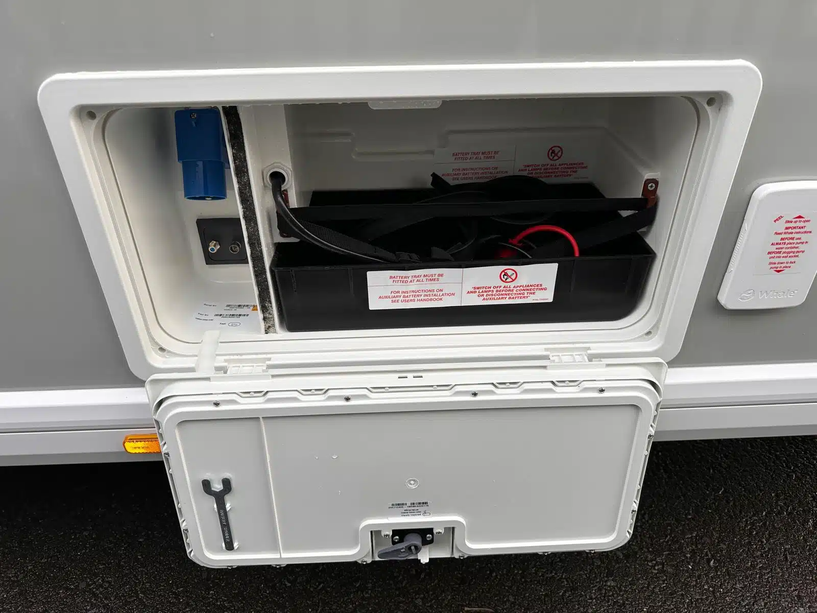 A caravan leisure battery being inspected safely inside its battery compartment